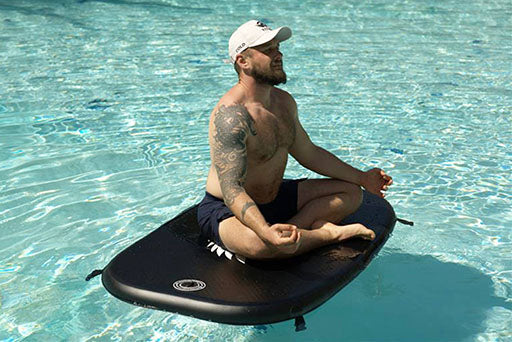 A person meditating on a Titan Inflatable Cover for Triumph XL in a pool